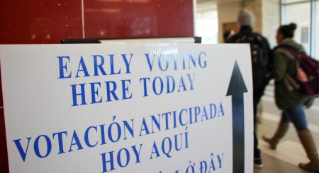 10-31-19 Early Voting White Sign at UH Student Center.  Two people in background out of focus.