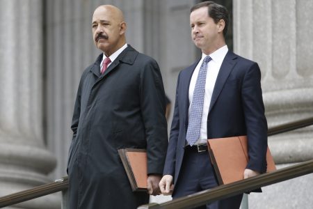 Ted Wells, Jr., left, the lead attorney for Exxon, leaves Manhattan Supreme court with a colleague Thursday, Nov. 7, 2019, in New York.  New York's attorney general is accusing Exxon Mobil of misleading investors about how profitable the company will remain as governments impose stricter regulations to combat global warming.
