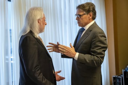 In this Nov. 12, 2018, photo provided by the U.S. Embassy in Kyiv, Energy Secretary Rick Perry talks with Michael Bleyzer during a speech in Kyiv, Ukraine. Bleyzer and Alex Cranberg, two political supporters of Perry secured a potentially lucrative oil-and-gas exploration deal from the Ukrainian government soon after Perry proposed one of the men as an adviser to the country’s new president.