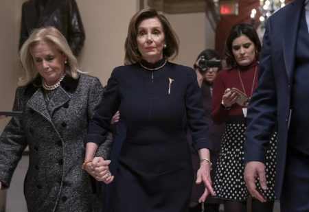 House Speaker Nancy Pelosi (D-Calif.) holds hands with Rep. Debbie Dingell (D-Mich.) as they walk to the chamber where the House begins debate on the impeachments charges against President Trump.