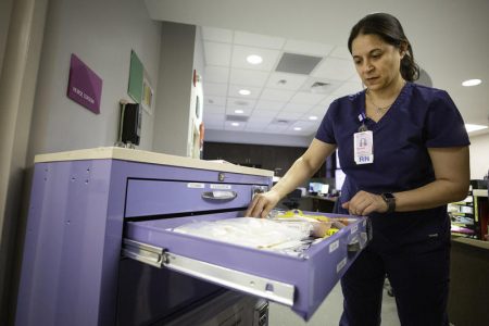 Nurse Rachelle Labonte opens the drawer of a "hemorrhage cart" at Ascension Seton Medical Center in Austin. The carts hold everything a doctor needs to treat a patient who is bleeding.