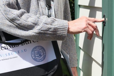 A U.S. Census worker goes door to door.
