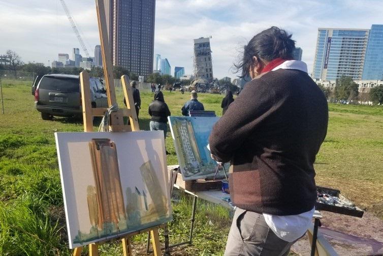 Artist painting the "Leaning Tower of Dallas" shortly before demolition began Monday morning.