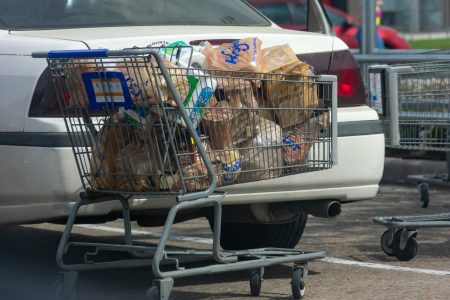 A shopper prepares to unload a full shopping cart of groceries in the parking lot of Kroger on North Shepherd on March 13, 2020.