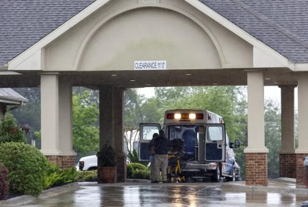 Paramedics disinfect a gurney in their ambulance before leaving a 131-bed nursing home in Tomball.