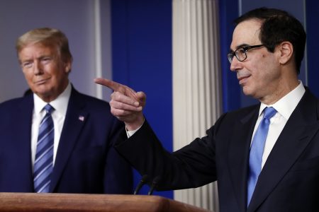 President Donald Trump listens as Treasury Secretary Steven Mnuchin speaks about the coronavirus in the James Brady Press Briefing Room of the White House, Tuesday, April 21, 2020, in Washington.
