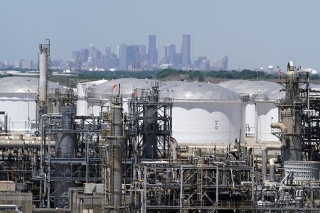 In this Thursday, April 30, 2020, photo storage tanks at a refinery along the Houston Ship Channel are seen with downtown Houston in the background.