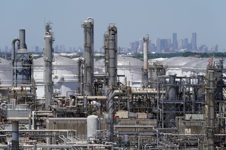In this Thursday, April 30, 2020, photo a refinery along the Houston Ship Channel is seen with downtown Houston in the background. Like in other cities, the coronavirus has shut down much of Houston's economic activity, slashing thousands of jobs, while at the same time, the price of oil plunged below zero recently as demand plummeted due to the worldwide lockdown to stop the spread of the virus. This one-two punch from COVID-19 and the collapse in oil prices will make it much harder for Houston to recover from a looming recession, according to economists.