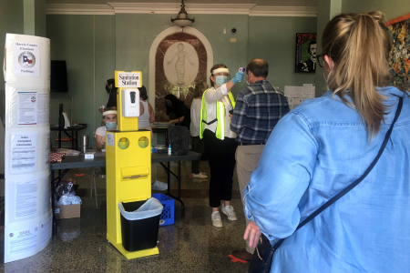 Voters at the Poe Elementary School polling place on July 14, 2020, are given a temperature check before entering.