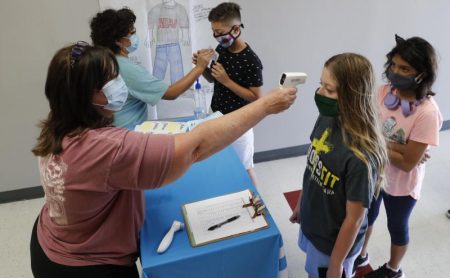 Science teachers Ann Darby, left, and Rosa Herrera check in students before a summer STEM camp at Wylie High School on July 14.