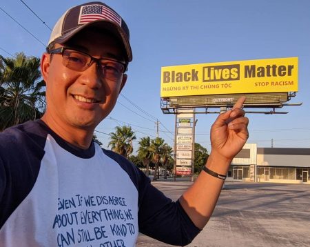 Nguyen Le stands in front of the Black Lives Matter sign he erected in Southwest Houston.