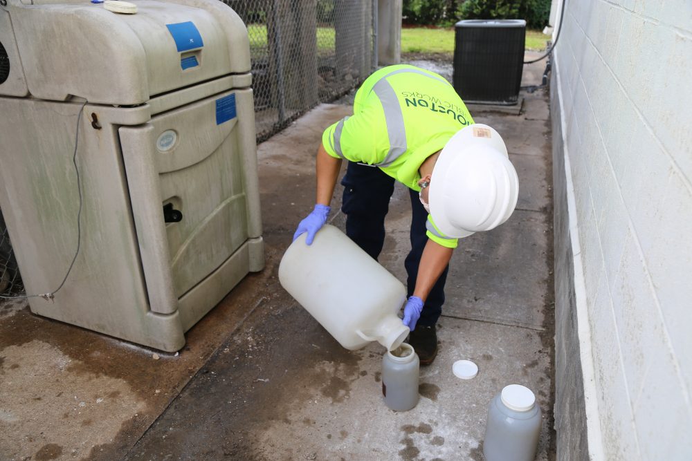 A plant worker from the Public Works department takes a sample of wastewater to test for the coronavirus. 