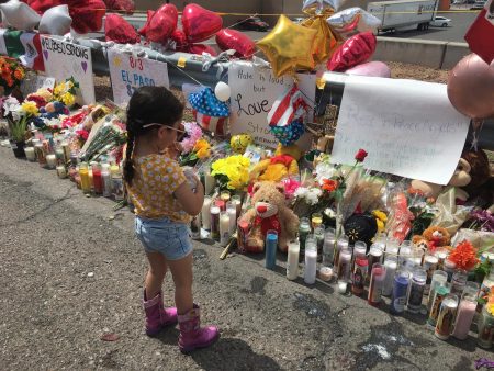 A little girl stands at a large makeshift memorial outside the Walmart in El Paso that was the site of a mass shooting August 3,2019.