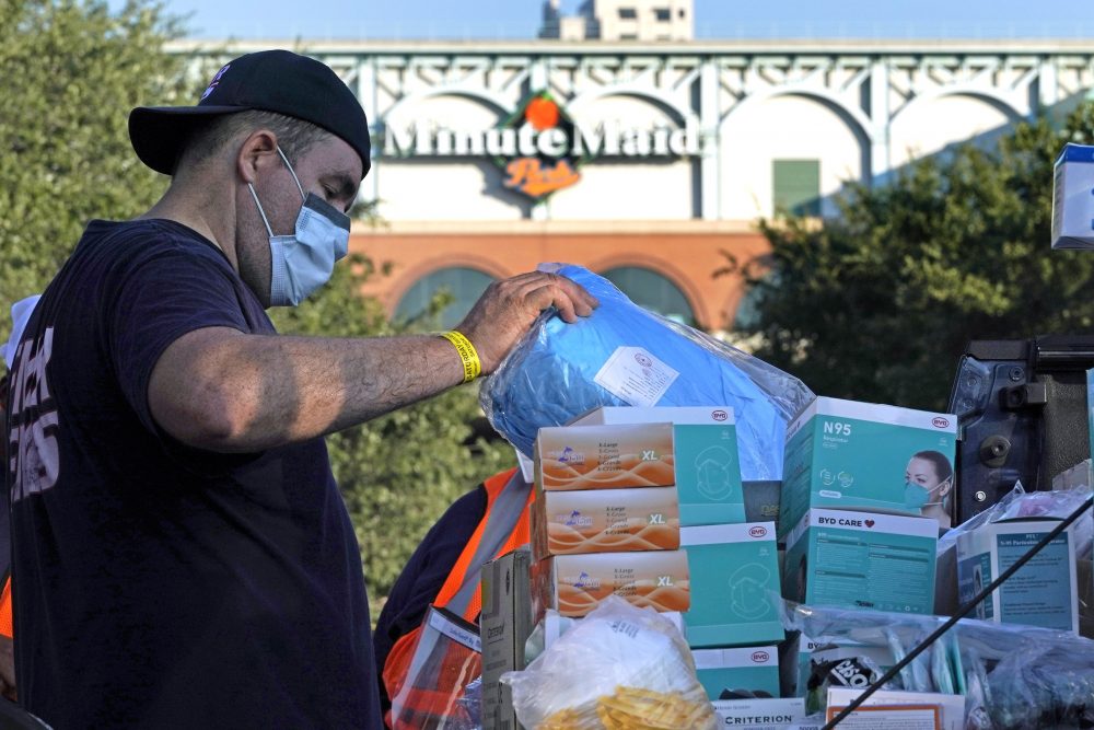 Edwin Reyes, with First Medical Response, sorts PPE at a Texas Division of Emergency Management free COVID-19 testing site at Minute Maid Park Saturday, Aug. 8, 2020, in Houston. The newly opened mega site, which has eight drive-thru lanes and four walk-up lanes, has the ability to process 2,000 tests per day.