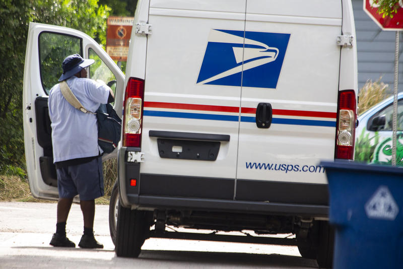A U.S. Postal Service worker delivers mail in Austin in March.