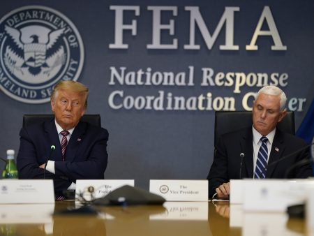 President Donald Trump and Vice President Mike Pence listen during a Hurricane Laura briefing at FEMA headquarters in Washington.