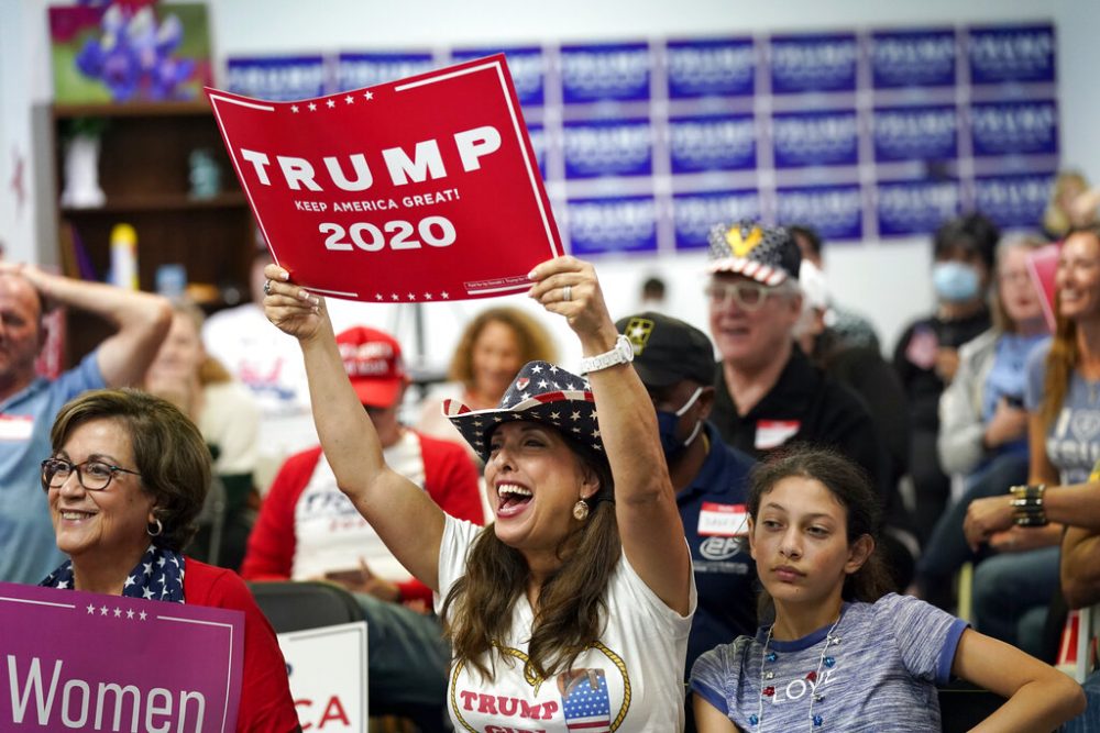 Emily McHattie, center, holds up a Trump 2020 sign while watching the presidential debate at a Republican watch party Tuesday, Sept. 29, 2020, in Katy.