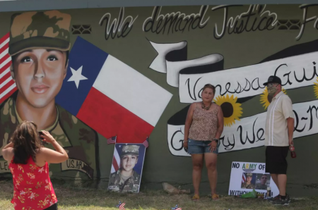 Larissa Martinez of the organization Circle of Arms takes photos at the unveiling of a San Antonio mural. It pays tribute to Vanessa Guillen and Gregory Wedel Morales, two Fort Hood soldiers who were found dead near the base in separate incidents this year.