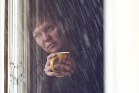 Lonesome Woman Drinking Coffee in Dark Room