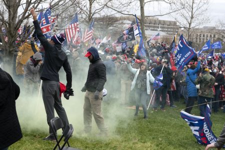 FILE - In this Jan. 6, 2021, file photo, supporter of President Donald Trump protest as U.S. Capitol Police officers shoot tear gas at demonstrators outside of the U.S. Capitol in Washington. Far-right social media users for weeks openly hinted in widely shared posts that chaos would erupt at the U.S. Capitol while Congress convened to certify the election results.
