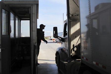 Border Patrol agent Eric Mendoza speaks to the driver of a tractor-trailer passing through the Laredo North vehicle checkpoint in Laredo, Texas, on Friday, Feb. 2, 2018. Smugglers routinely pack people entering the country illegally or drugs into tractor-trailers, counting on the vehicles not being opened at the inspection site.