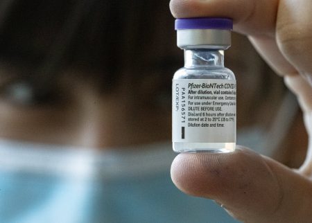 A medical worker holds up a vial of the Pfizer-BioNTech COVID-19 vaccine while applying a second dose to health workers at Posta Central Hospital in Santiago, Chile, Friday, Jan. 15, 2021.