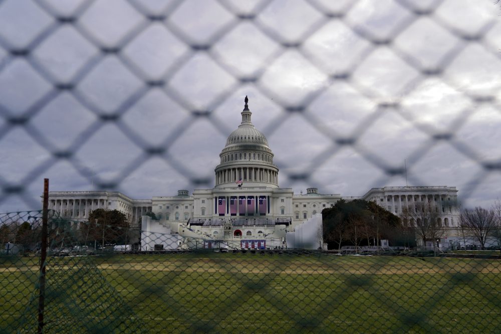 The U.S. Capitol is visible behind fences on Sunday following the Jan. 6 riot by pro-Trump extremists. This week's events will have the largest security presence of any inauguration in U.S. history.