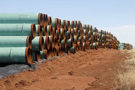 In this Feb. 1, 2012 file photo, miles of pipe ready to become part of the Keystone Pipeline are stacked in a field near Ripley, Okla.