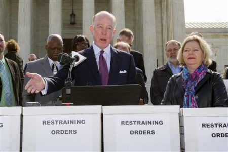 Dr. Steven Hotze, president of Conservative Republicans of Texas, speaks at a Restrain the Judges news conference, while Janet Porter of Faith2Action listens at right, in front of the Supreme Court in Washington, Monday, April 27, 2015.