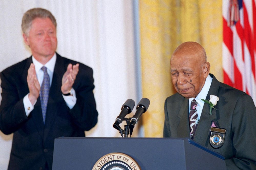 Herman Shaw speaks as President Bill Clinton looks on during a White House event where Clinton apologized to the survivors and families of the victims of the Tuskegee Syphilis Study. Shaw was one of hundreds of Black men who were part of a government study that followed the progress of syphilis and were told that they were being treated, but were actually given only a placebo.