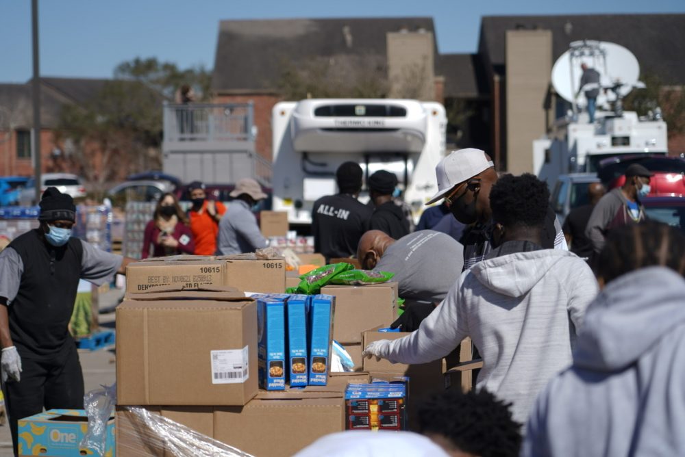 People wait in line for food and water at a Houston distribution site organized by U.S. Rep. Al Green on Feb. 22, 2021.