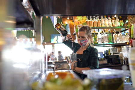 Bartender Alyssa Dooley makes a cocktail at Mo's Irish Pub, Tuesday, March 2, 2021, in Houston. Texas Gov. Greg Abbott announced Tuesday that he is lifting business capacity limits and the state's mask mandate starting next week.