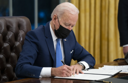 In this Feb. 2, 2021, file photo president Joe Biden signs an executive order on immigration, in the Oval Office of the White House in Washington. The Biden administration is facing growing questions about why it wasn't more prepared for an influx of migrants at the southern border. The administration is scrambling to build up capacity to care for 14,000 young undocumented migrants now in federal custody — and more likely on the way.