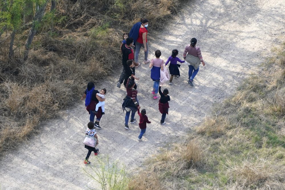 Migrants walk on a dirt road after crossing the U.S.-Mexico border, Tuesday, March 23, 2021, in Mission, Texas. A surge of migrants on the Southwest border has the Biden administration on the defensive. The head of Homeland Security acknowledged the severity of the problem but insisted it's under control and said he won't revive a Trump-era practice of immediately expelling teens and children. (AP Photo/Julio Cortez)