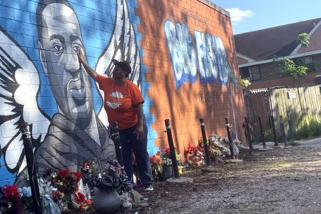 Rowena Jesse, 62, touches a mural of George Floyd in Houston's Third Ward on April 20, 2021, after Minnesota Police Officer Derek Chauvin was found guilty of his murder.