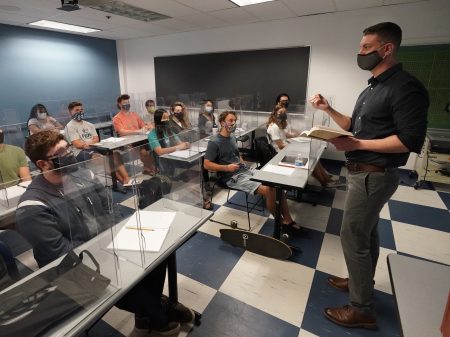 The CDC announced Thursday that fully vaccinated people can safely stop wearing masks indoors. Kyle Faircloth, Associate Professor of Intercultural Studies, is seen teaching a class at Palm Beach Atlantic University in West Palm Beach, Fla., in February.