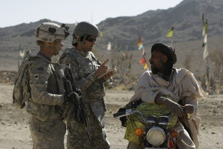 US Army Sgt. Skyler Rosenberry of Pennsylvania, left, and an Afghan interpreter, center, from First Battalion, 502nd Infantry Regiment, 101st Airborne Division speak to an Afghan man during a foot patrol in West Now Ruzi village, district Panjwai, Afghanistan's Kandahar province, Wednesday, Nov. 24, 2010. (AP Photo/Alexander Zemlianichenko)