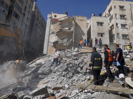 People search for victims under the rubble of a destroyed building in Gaza City's Rimal residential district on Sunday, following Israeli airstrikes.