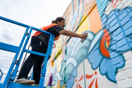 Artist David Maldonado paints a mural on Polk St. for the Big Walls Big Dreams Art Festival on May 20, 2021.