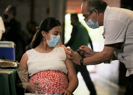 A pregnant woman gets a Pfizer vaccine shot for COVID-19 at a library converted into a vaccination center in Mexico City, Thursday, May 13, 2021. (AP Photo/Fernando Llano)
