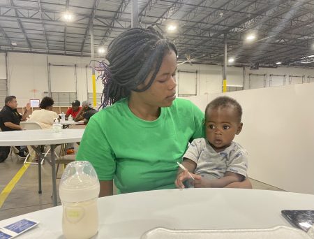 At the new family transfer center in north Houston, Haitian migrant Jouseline Metayer sits with her 7-month-old son, Jayden.