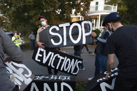 FILE - In this Oct. 14, 2020, file photo, housing activists erect a sign in front of Massachusetts Gov. Charlie Baker's house in Swampscott, Mass. A moratorium put in place by the Centers for Disease Control in September that protects certain renters from eviction expires at the end of the year.