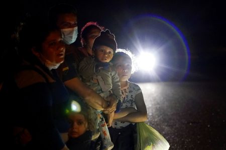 In this May 17, 2021 file photo, a group of migrants mainly from Honduras and Nicaragua wait along a road after turning themselves in upon crossing the U.S.-Mexico border, in La Joya, Texas. The Biden administration announced Tuesday, June 15, 2021, that it was expanding a newly-revived effort to bring Central American children to the United States to reunite with parents legally living in the country.