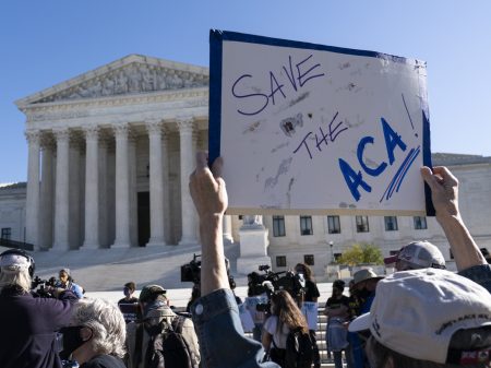 A demonstrator holds a sign in support of the Affordable Care Act in front of the U.S. Supreme Court last November. On Thursday, the justices did just that.