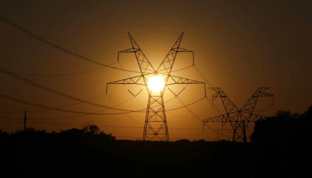 The sun sets on electrical power lines in Grand Prarie, Texas, Wednesday, April 30, 2014.