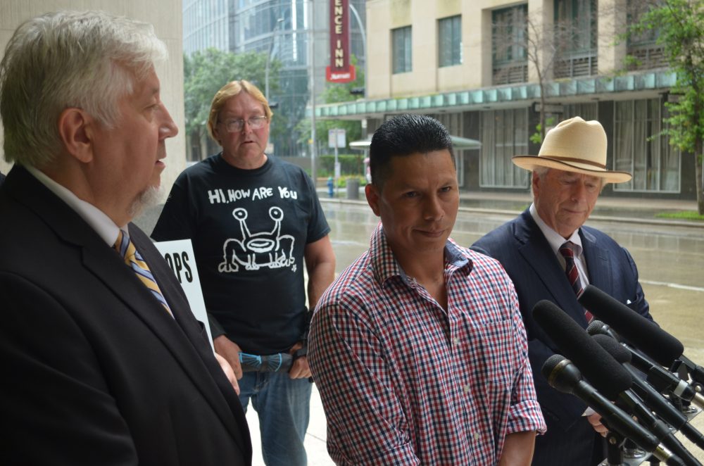 Jose Gomez is flanked by his attorneys Randall Kallinen, left, and Dick GeGuerin for a news conference outside HPD headquarters.