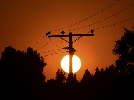 The sun sets behind power lines in Los Angeles, California on September 3, 2020, ahead of a heatwave to arrive September 4 through the Labour Day weekend prompting a statewide flex alert. (Photo by Frederic J. BROWN / AFP) (Photo by FREDERIC J. BROWN/AFP via Getty Images)