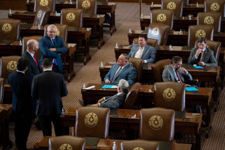 Legislators talk amongst themselves on the House floor on July 29, 2021.