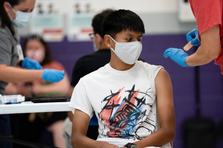 Anthony Peña, 15, sits after receiving a dose of the Pfizer vaccine at a clinic organized by the Travis County Mobile Vaccine Collaborative at Rodriguez Elementary School on July 28, 2021.