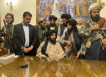 Taliban fighters take control of Afghan presidential palace after the Afghan President Ashraf Ghani fled the country, in Kabul, Afghanistan, Sunday, Aug. 15, 2021. Person second from left is a former bodyguard for Ghani.